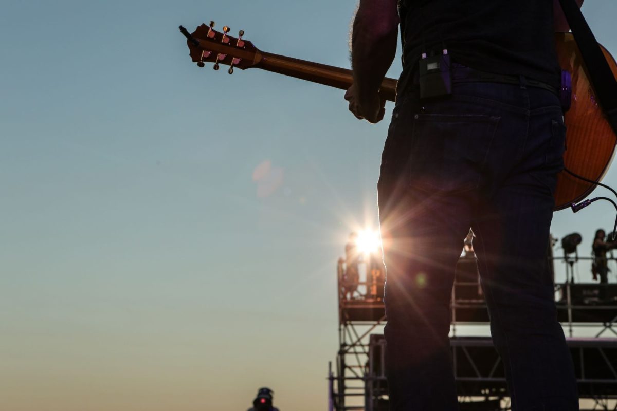 man plays guitar at country music festival